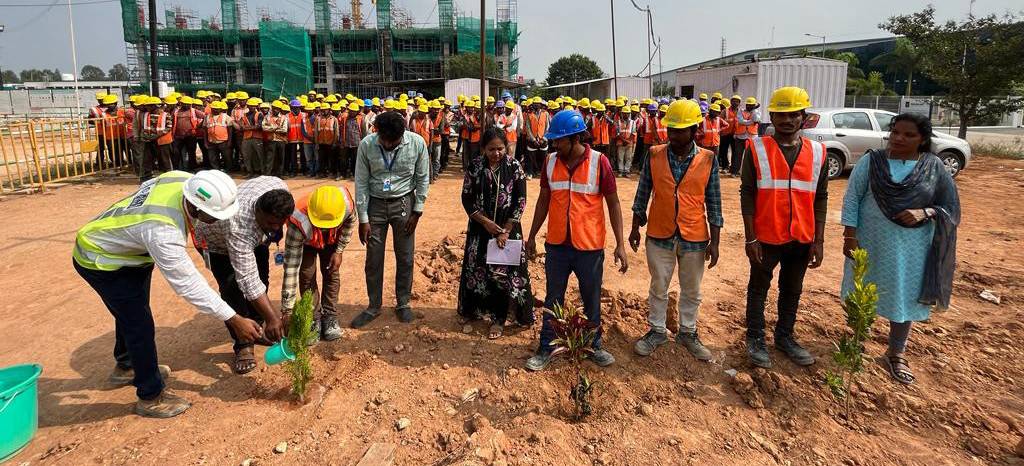 Tree planting with construction workers on a building site