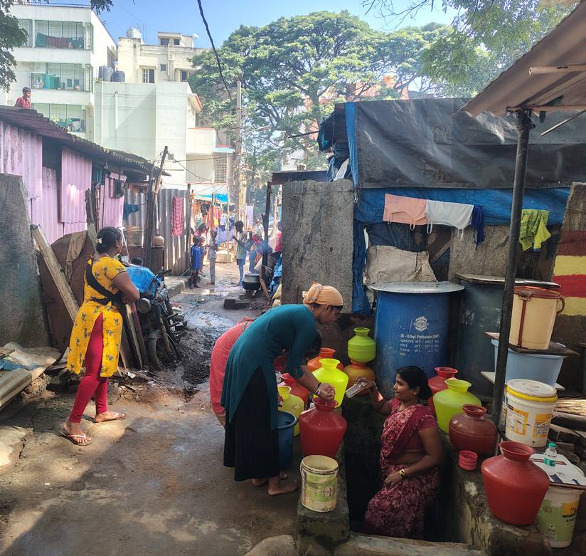 Residents collecting water in a dense Bengaluru lane